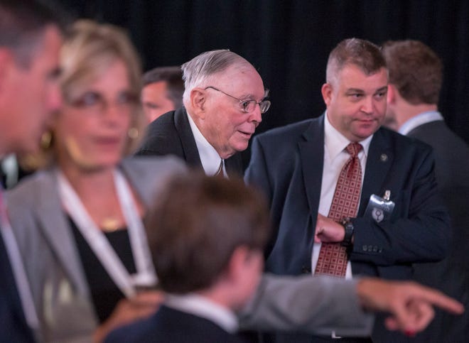Berkshire Hathaway Vice Chairman Charlie Munger, center, arrives to the annual shareholders meeting in Omaha, Neb., Saturday, May 2, 2015. More than 40,000 people are expected to attend the shareholder meeting to listen to CEO and Chairman Warren Buffett and Vice Chairman Charlie Munger.