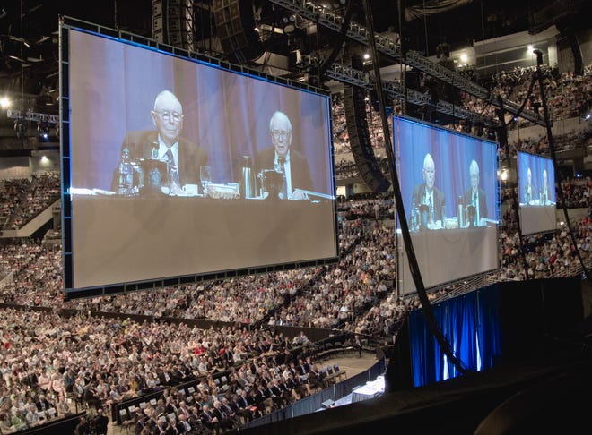 Warren Buffett, chairman and CEO of Berkshire Hathaway, right, and his vice chairman Charlie Munger, are seen on big screens as preside over the Berkshire Hathaway shareholders meeting in Omaha, Neb., Saturday, May 5, 2012.