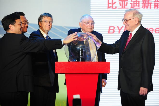 Leading US businessmen Warren Buffett (R), Charles Munger (C) and Bill Gates (3rd L) join Deng Xiaogang (2nd L), vice chairman of Tibet Autonomous Region (TAR) and Wang Chuanfu (L), president and chairman of BYD, join together to touch a globe at the nationwide launch ceremony of Chinese electric vehicle BYD M6 in Beijing on September 29, 2010. US billionaire investor Buffett said the previous day that Chinese battery and auto maker BYD was the "right choice for me", two years after his Berkshire Hathaway bought a stake in the firm. Gates and Buffett were to host a banquet for China's super-rich which has sparked debate about Chinese philanthropy, amid reports that wealthy invitees have been reluctant to attend.